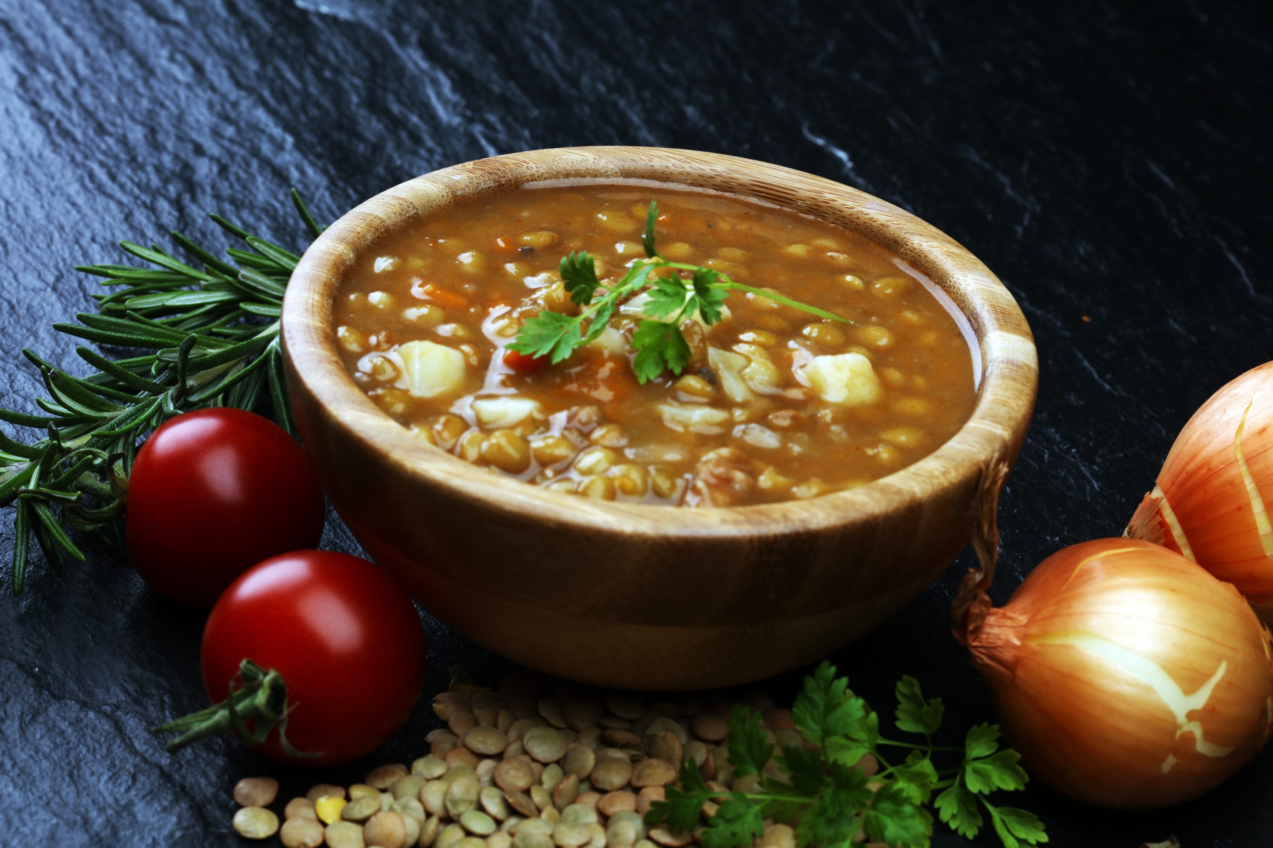 Lentil soup with pita bread in a bowl on a wooden background